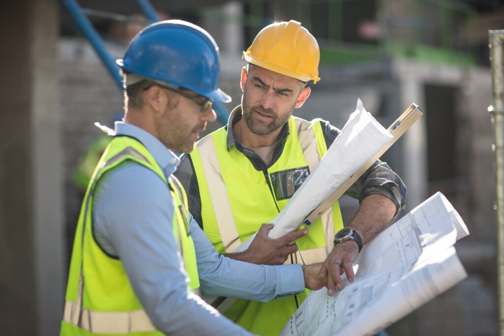 Project manager and construction worker looking at plans